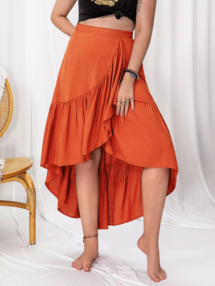 Person wearing an orange ruffled skirt on a white background