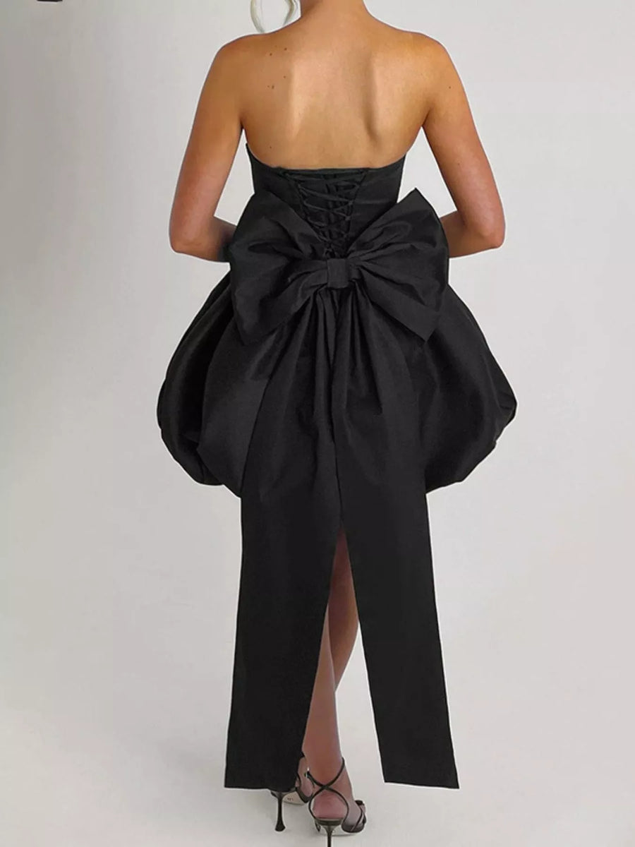 Black strapless dress with a large bow detail on a white background