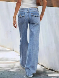 Person wearing light blue flared jeans on a white background