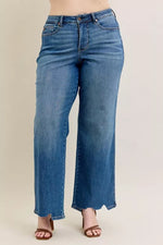 Blue jeans worn by a person on a beige background