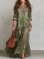 Woman wearing an olive green outfit with a brown bag against a neutral background