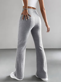 Person wearing gray ribbed pants on a plain background