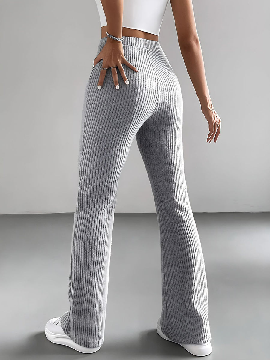 Person wearing gray ribbed pants on a plain background