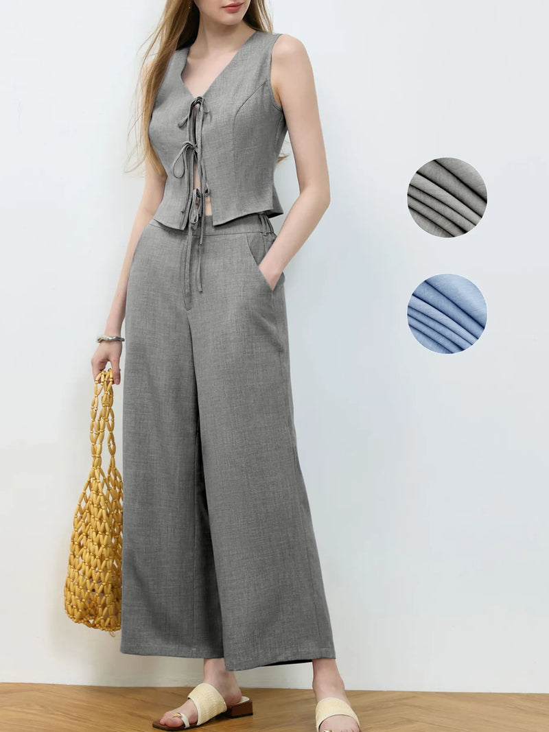 Woman wearing a gray sleeveless top and wide-leg pants with fabric swatches on a white background