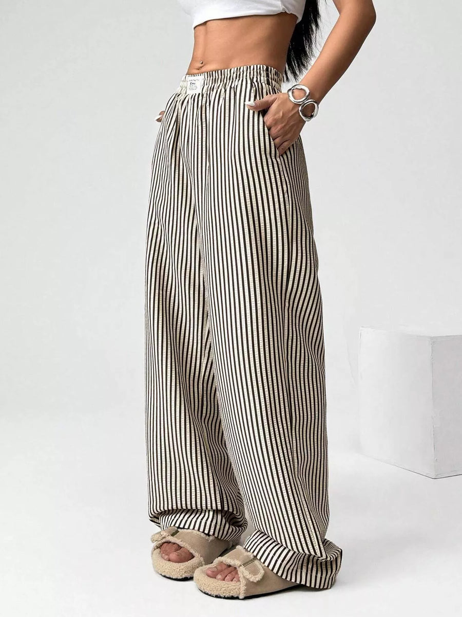 Person wearing black and white striped wide-leg pants on a white background