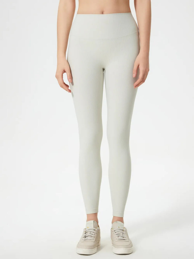 Person wearing light gray leggings on a white background