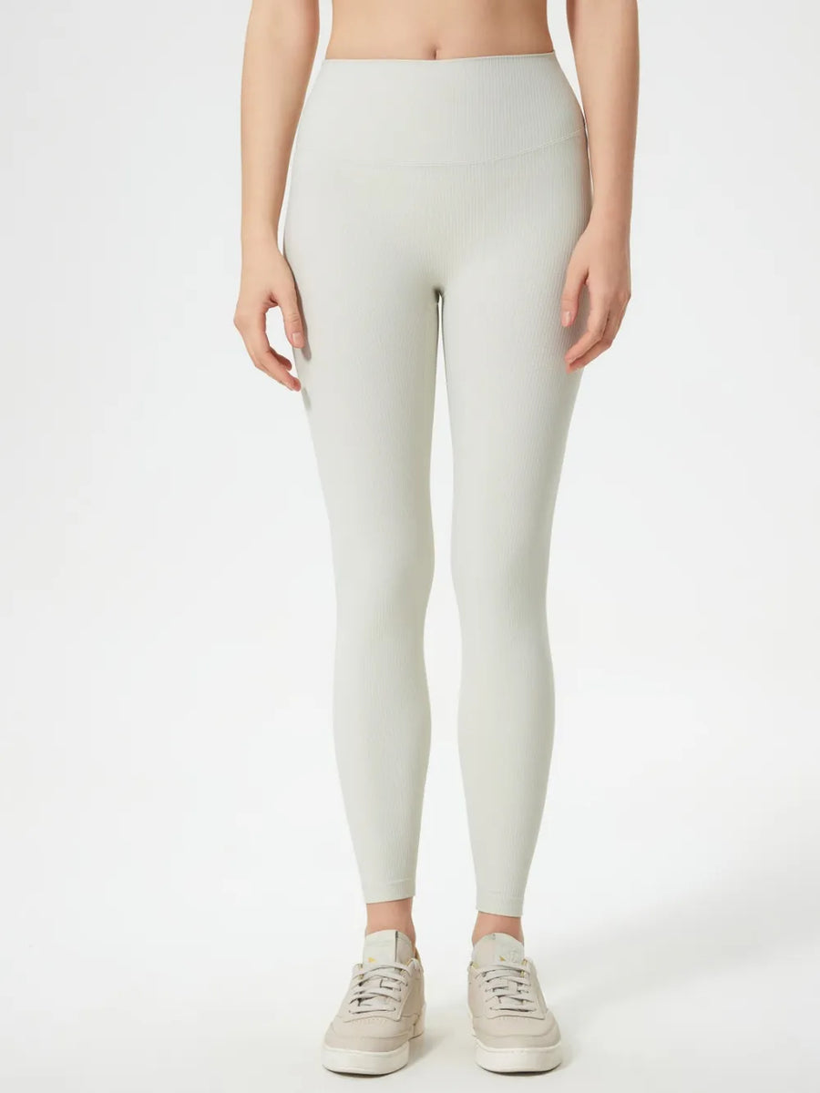 Person wearing light gray leggings on a white background