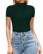 Person wearing a dark green short-sleeve top and light blue jeans on a white background