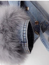 Close-up of a denim jacket with fur trim on a white background