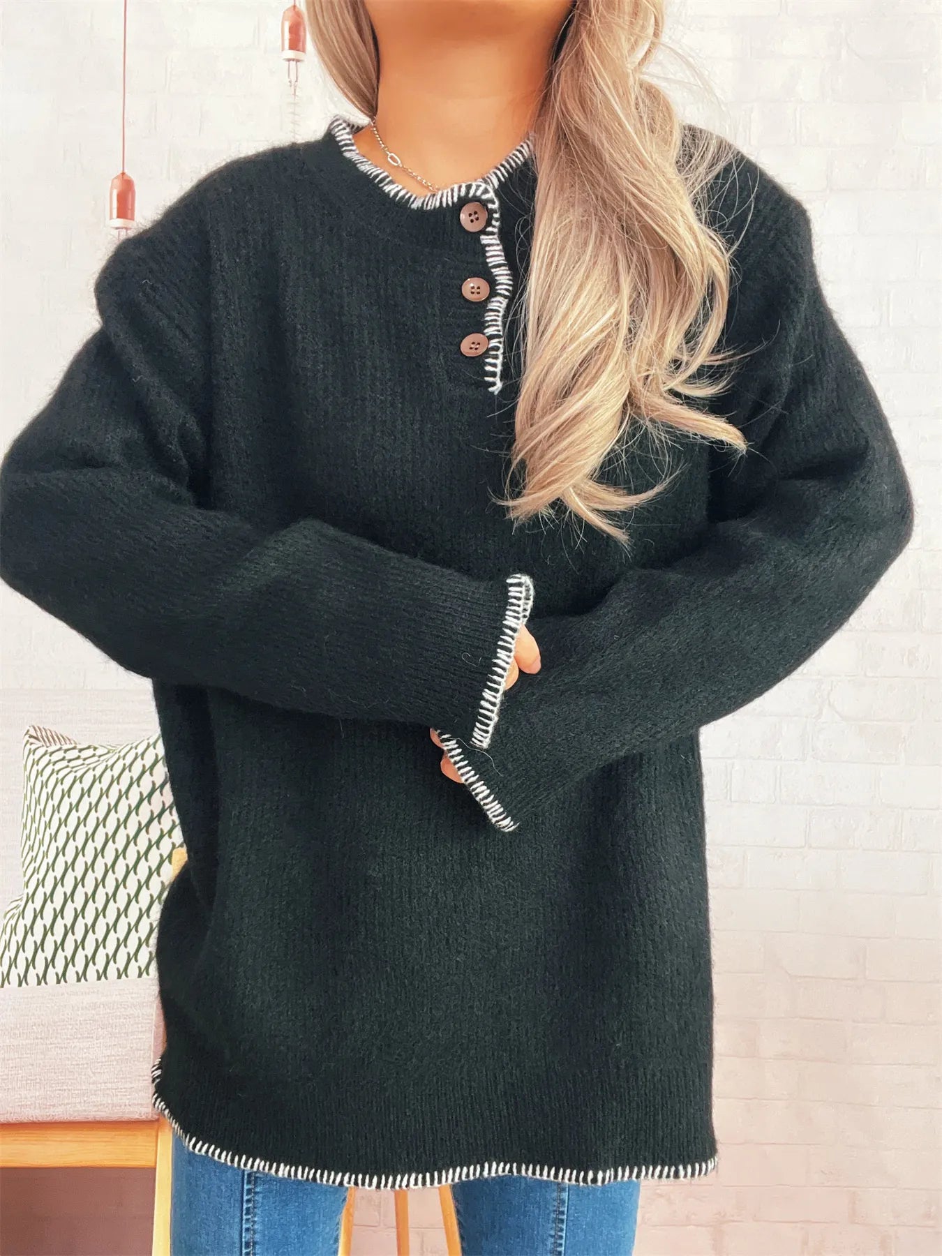 Person wearing a dark green sweater with a blurred background