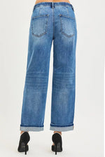 Lady showing the back of Blue jeans with a white background