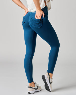 Person wearing blue leggings with a plain background