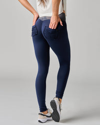 Person wearing navy blue leggings with textured waistband on a gray background