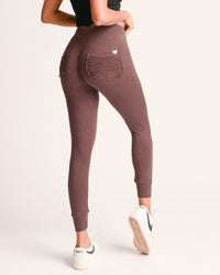 Brown leggings with a heart pocket worn by a person on a white background