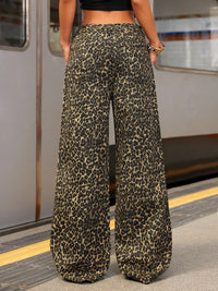Person wearing leopard print pants on a subway platform
