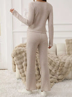 Person wearing a ribbed knit outfit in a cozy room with soft lighting.