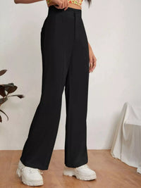Person wearing black wide-leg pants with a white background