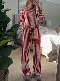 Person wearing red and white striped pajamas in a bedroom.