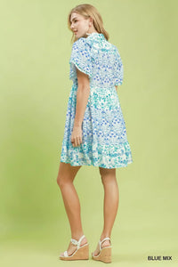 Woman wearing a blue floral dress on a green background