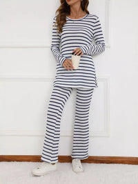 Person wearing a blue and white striped pajama set holding a cup against a white background