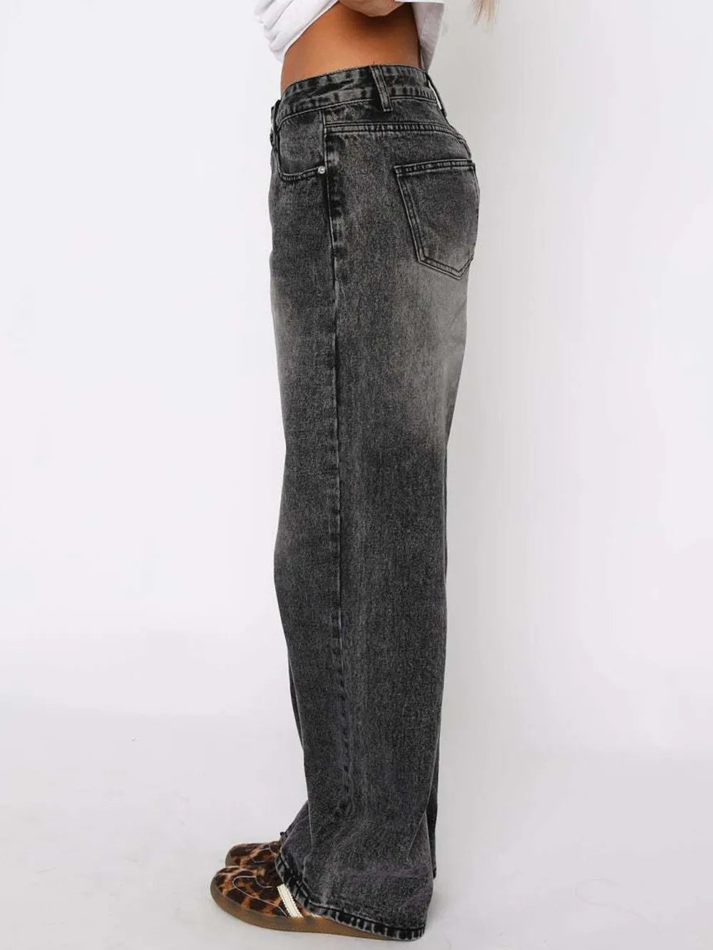 Black jeans worn by a person on a white background