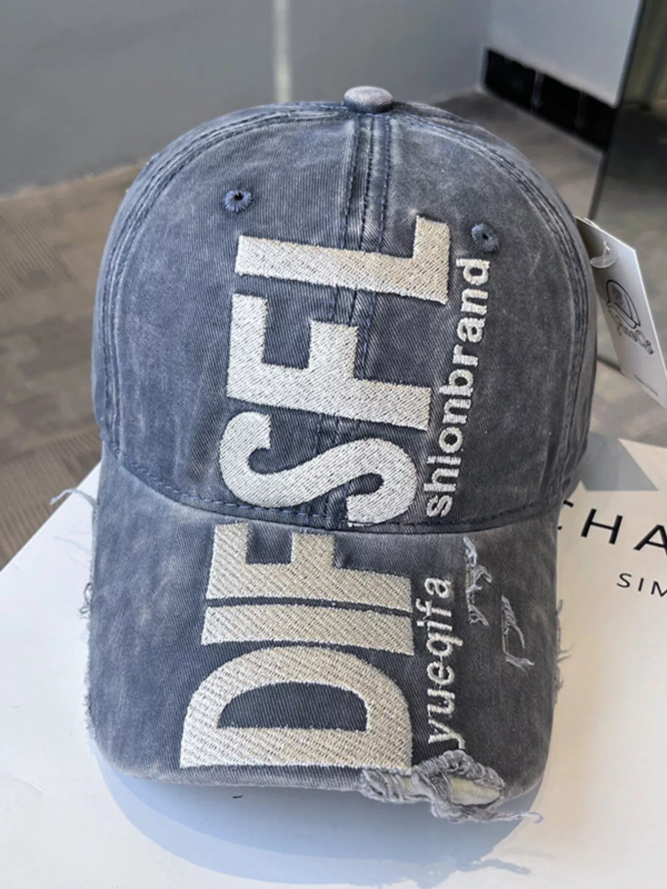 Blue denim cap with 'DIESEL' branding on a white surface