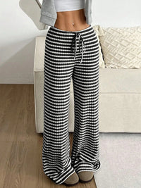 Person wearing black and white checkered pants in a living room setting