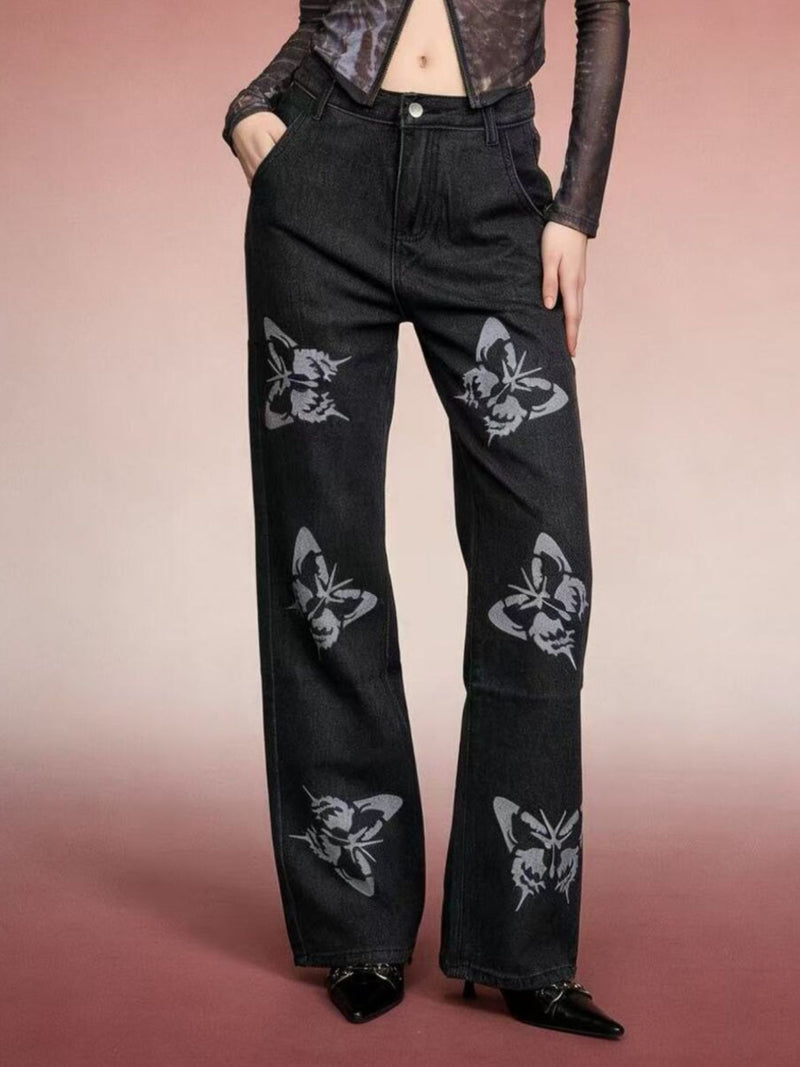 Person wearing black jeans with butterfly patterns on a gradient background