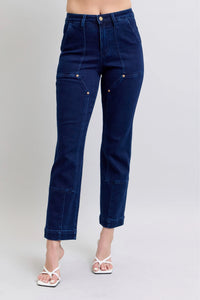 Navy blue jeans worn by a person on a plain background