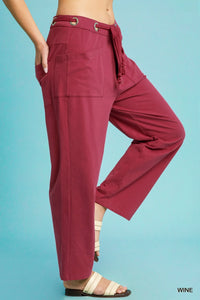 Maroon wide-leg pants with a belt on a blue background