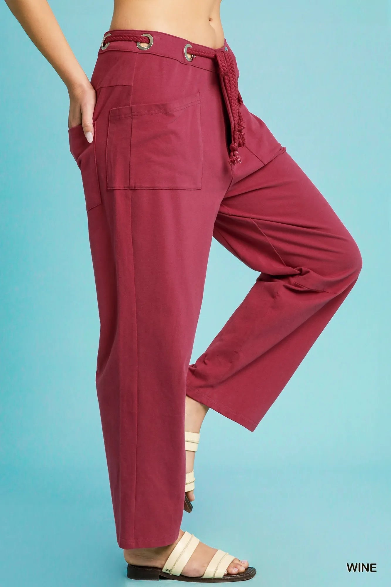 Maroon wide-leg pants with a belt on a blue background