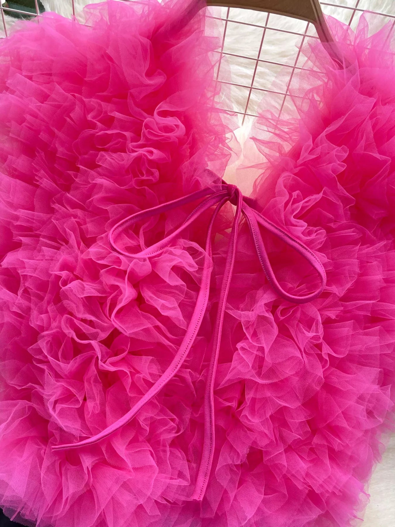Close-up of a bright pink tutu with a bow in the center.