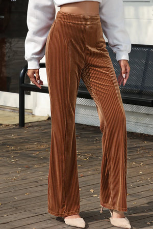 Person wearing brown corduroy pants on a wooden deck.
