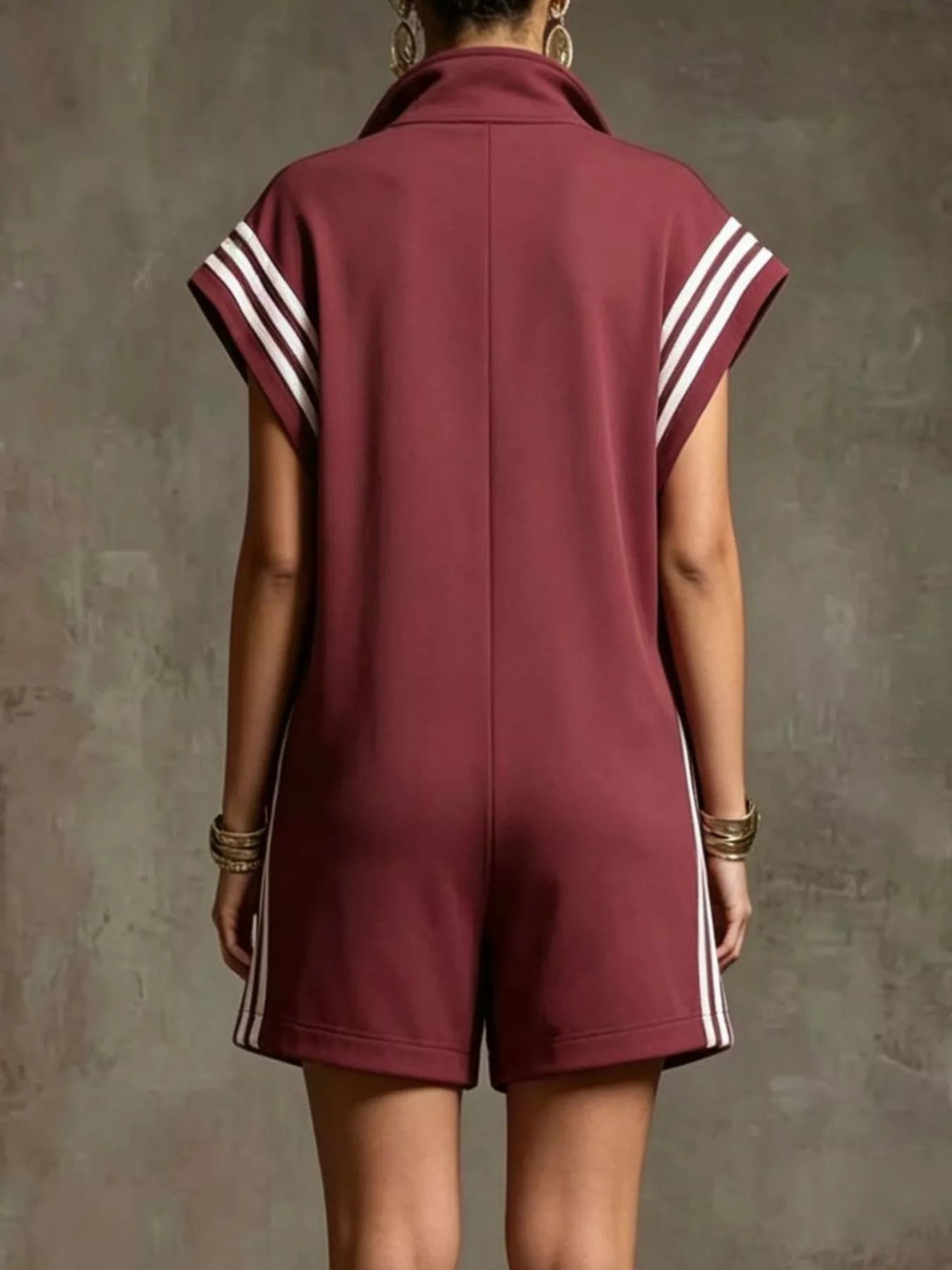 Maroon romper with white stripes on a textured gray background