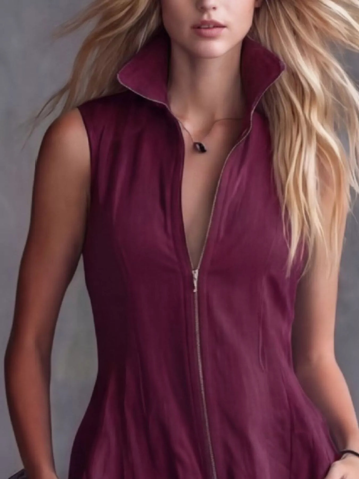 Woman wearing a deep-neck burgundy dress with a zipper.