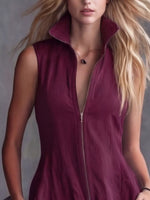 Woman wearing a deep-neck burgundy dress with a zipper.