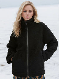 Woman wearing a black fleece jacket in a snowy landscape