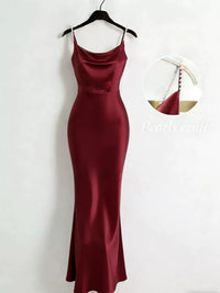 Burgundy dress on a hanger against a white background