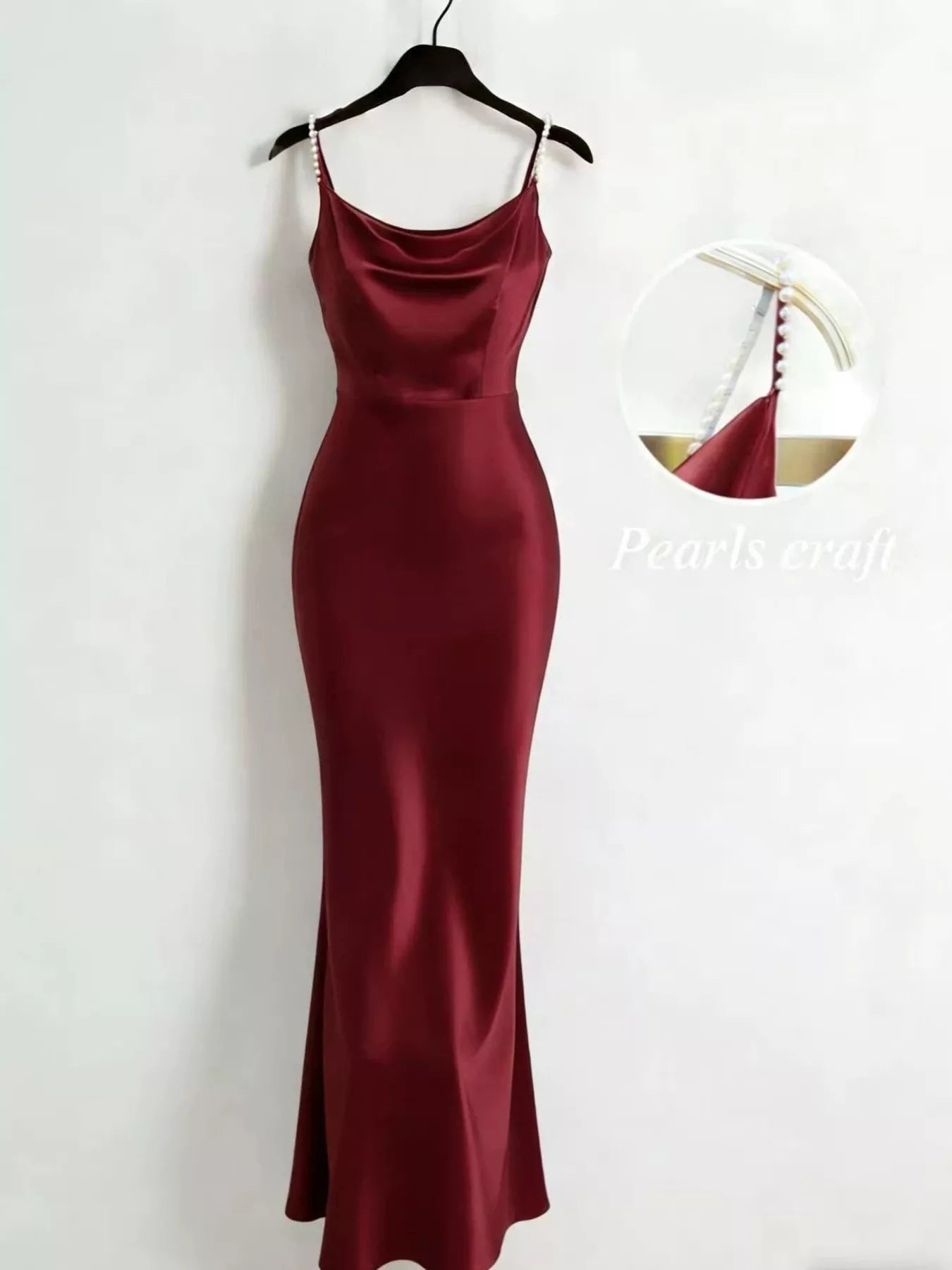 Burgundy dress on a hanger against a white background