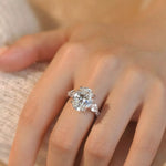 Diamond ring on a person's finger with a soft focus background