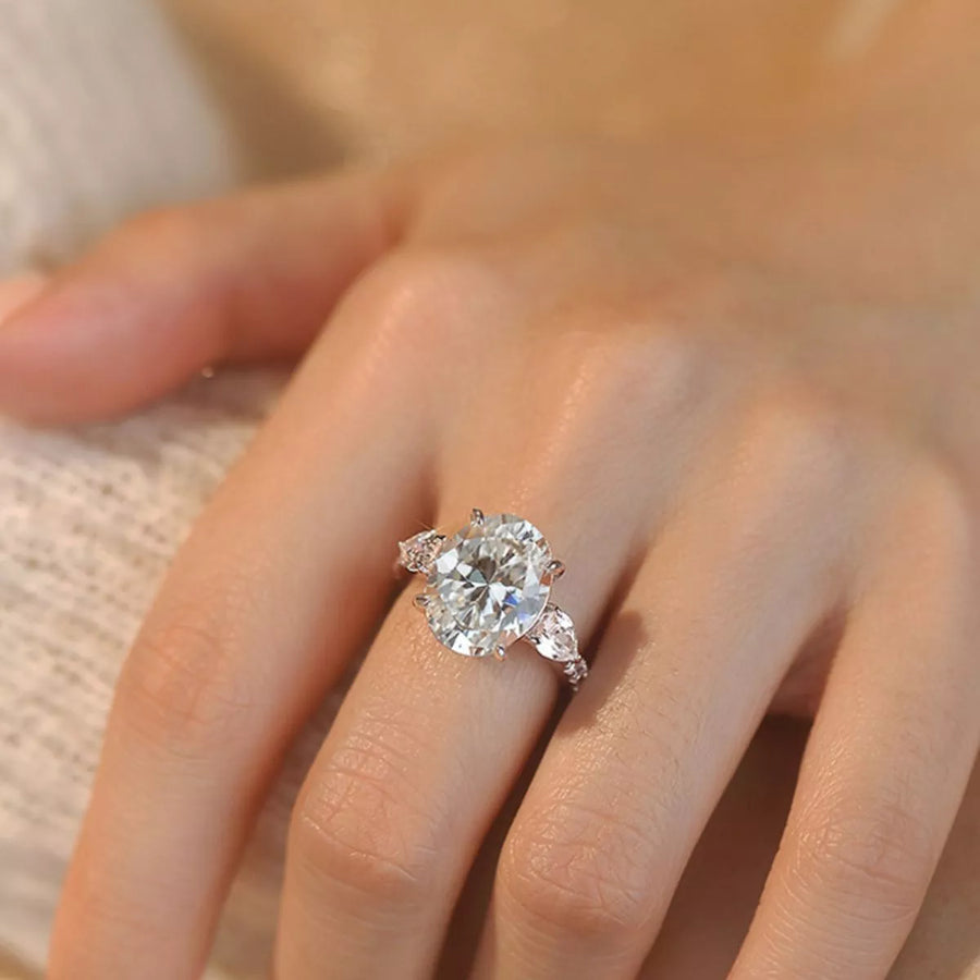Diamond ring on a person's finger with a soft focus background