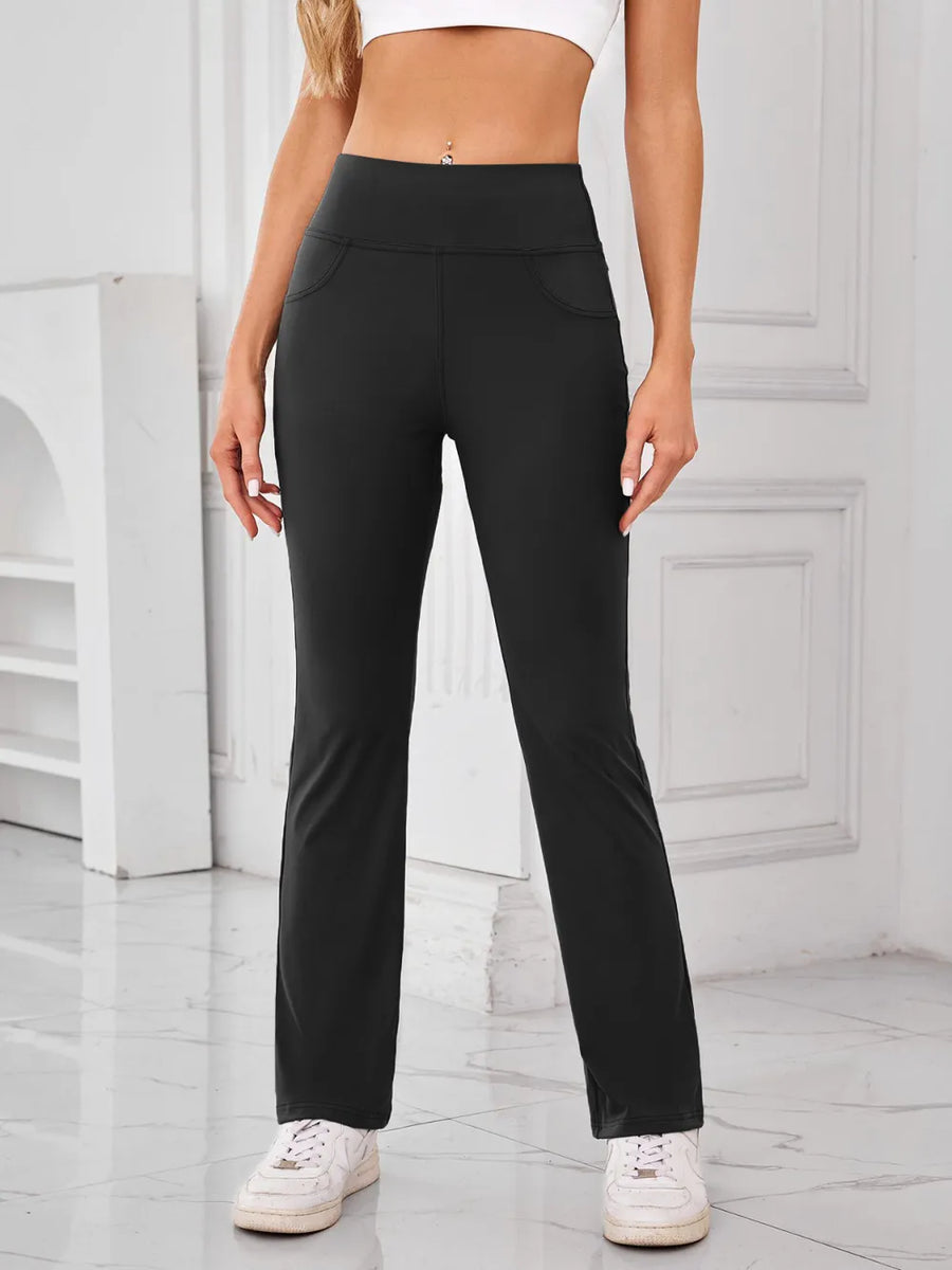 Person wearing black pants and white sneakers in a minimalistic setting