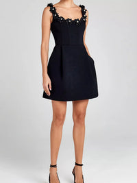 Black dress with floral embellishments on a white background