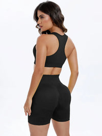 Woman wearing a black sports bra and high-waisted shorts on a white background