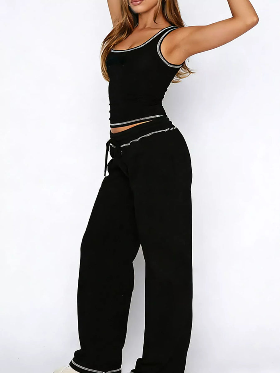 Person wearing a black outfit with white trim on a white background