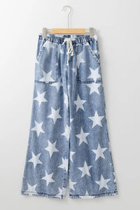 Blue denim pants with white star pattern on a hanger against a white background