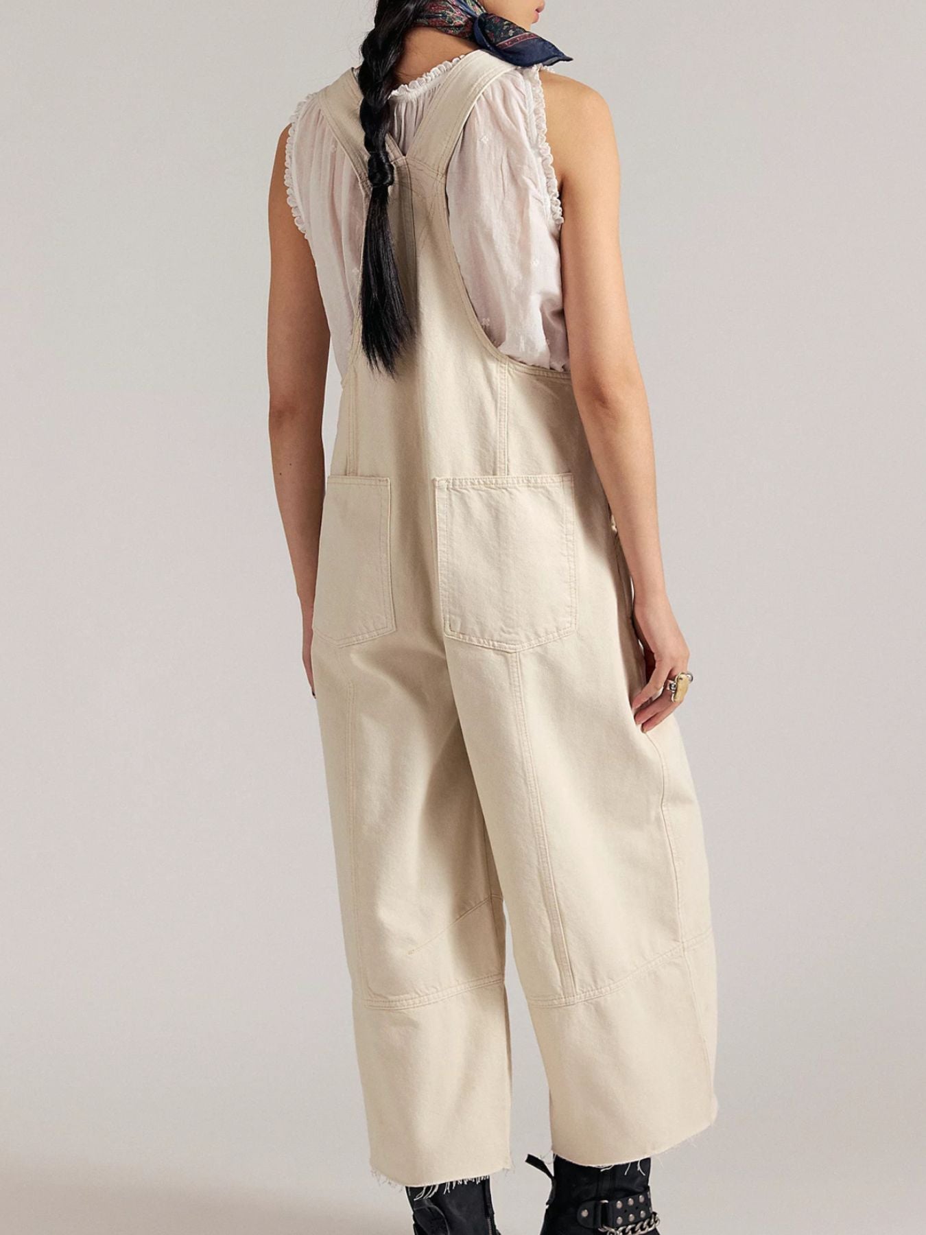Person wearing beige overalls on a plain background