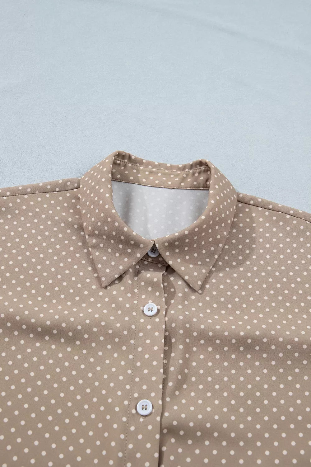 Brown shirt with white polka dots on a light gray background