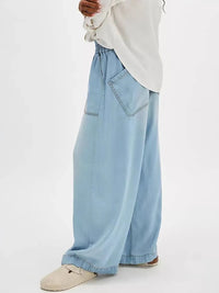 Light blue wide-leg jeans worn by a person on a white background