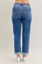 Blue jeans worn by a person on a plain background